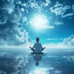 Person meditating in lotus pose on reflective water surface with serene blue sky and clouds background.