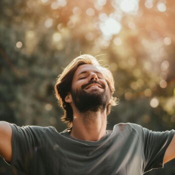 Man enjoying sunshine with arms wide open outdoors